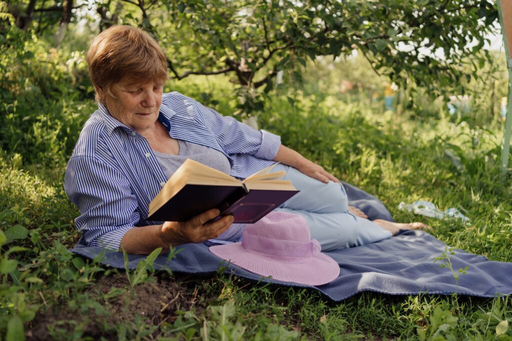 Senior woman reading a book in nature
