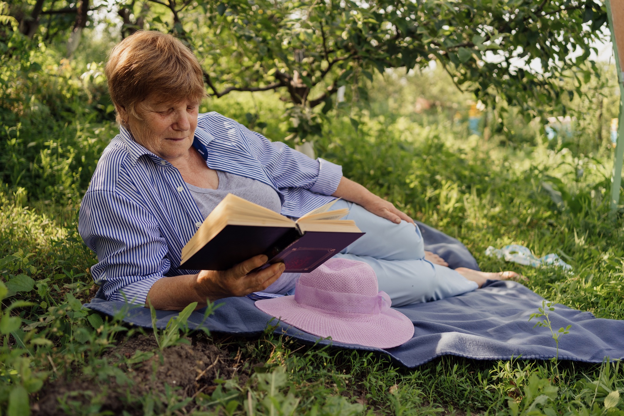 Senior woman reading a book in nature